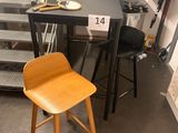 deux tabourets et une table sur laquelle est posé un ordinateur portable