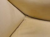 the back of a tan leather couch with a white pillow