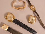 three different watches and a knife on a table