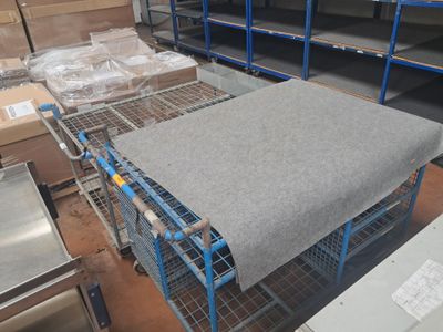 un chariot métallique sur lequel est posé un matelas, dans un entrepôt
