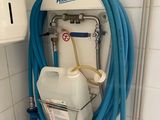 un tuyau bleu raccordé à un réservoir blanc dans une salle de bains