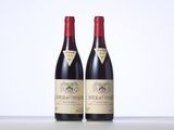 two bottles of red wine sitting on top of a table