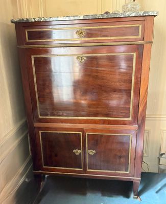 a small cabinet with a marble top in a room