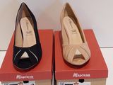 deux paires de chaussures noires et beiges posées sur des cartons