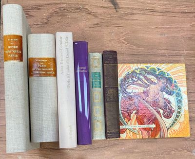 des livres et d'autres objets posés sur une table en bois à côté d'un rouleau de papier