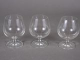 three empty wine glasses sitting next to each other on a table