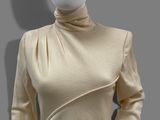 a mannequin mannequin wearing a beige top and black pants