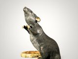 a statue of a rat sitting on top of a banana