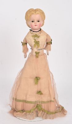 an antique doll of a woman in a dress and hat