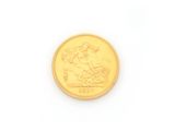 a close up of a gold coin on a white surface