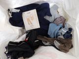 a bag full of clothes and a book on the bed