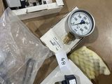 a box with a gauge and a box of other items on a table