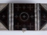an antique silver and wood box with a design on the inside