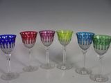 several different colored wine glasses are lined up in a row