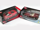 une petite voiture rouge dans une boîte sur une surface blanche
