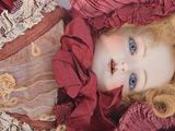 a close up of a doll wearing a red dress