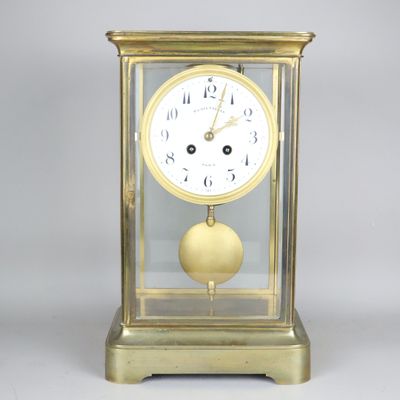 une horloge en or surmontée d'un couvercle en verre