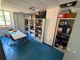a room with a table, chairs, and bookshelves in it