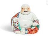 une figurine représentant un Bouddha souriant assis sur un coussin