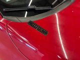 a close up of a red car with a sticker on it