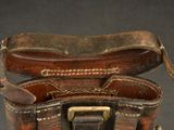 a brown leather bag with a metal buckle on it