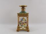 a small gold and blue vase with flowers on it
