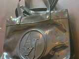 le sac à main est brillant et porte un petit logo