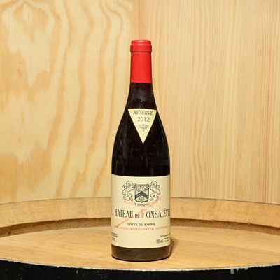 a bottle of wine sitting on top of a barrel