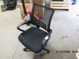 a black office chair with a black seat in a warehouse