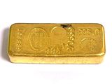 une image représentant un lingot d'or posé sur une surface blanche