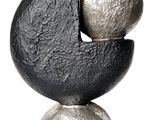 une sculpture noire et argentée posée sur un socle en marbre