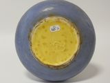 a blue and yellow vase sitting on a white surface