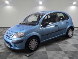 la photo d'une petite voiture bleue garée sur un sol en damier
