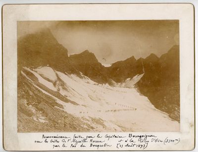 une vieille photo montrant un groupe de personnes gravissant une montagne enneigée