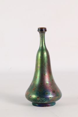 un vase en verre vert avec un couvercle noir posé sur une surface blanche