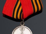 an old medal with a ribbon around it on a black surface