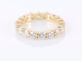 a yellow gold ring with white diamonds on a white background