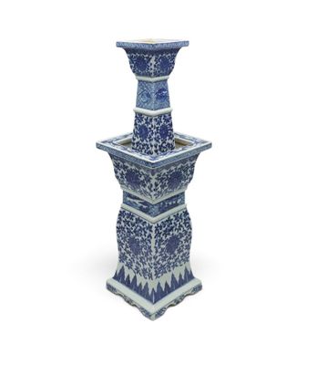 tall blue and white vase with a floral design on the base