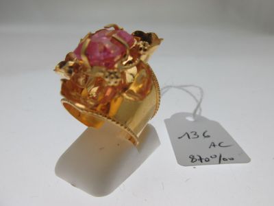 une bague en or sertie d'une pierre rose