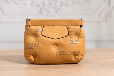 une photo d'un sac à main marron posé sur une table en bois