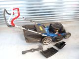 a blue lawn mower with a red handle on the ground