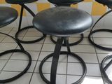 four stools that are sitting on a tiled floor