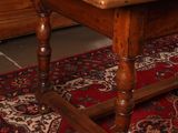 a large wooden table with a red rug on the floor