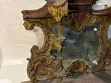 a mirror with a statue of a woman and a man on it