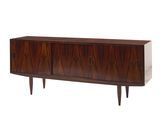 Le buffet est en bois et comporte deux tiroirs.