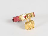 un bracelet rouge orné d'une breloque en forme d'éléphant doré