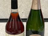 two bottles of wine sitting next to each other on a counter