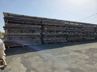 un gros tas de tuyaux en acier empilés sur un parking