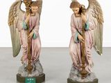two figurines of angels are sitting on top of a table