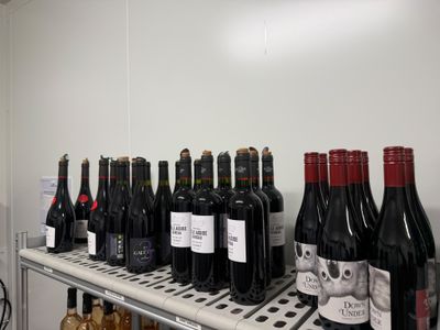 plusieurs bouteilles de vin posées sur une étagère dans une pièce